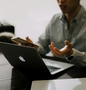 Man sitting with a laptop at a desk.