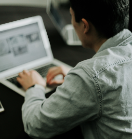 Man sitting with a laptop at a desk.