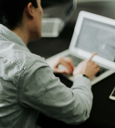 A man sitting with a laptop.